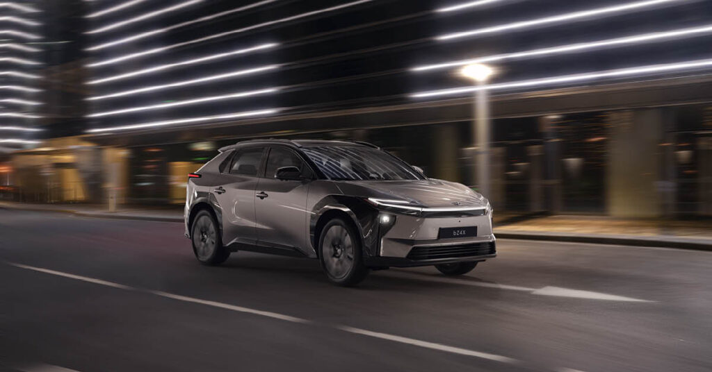 En ny Toyota bZ4X kör i stadsmiljö.