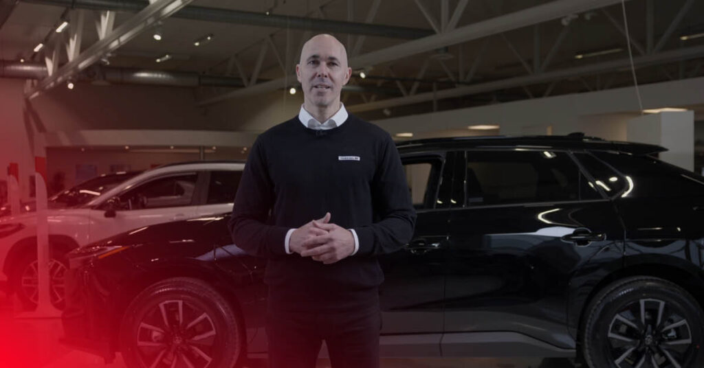 Lindströms Bils produktexpert står framför en svart Toyota bZ4X.
