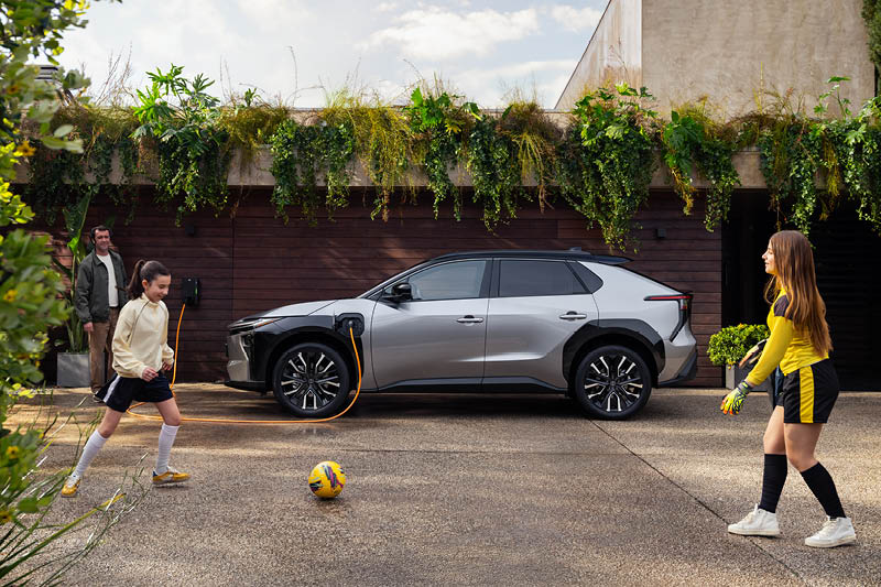 Två barn som leker framför en Toyota bZ4X.